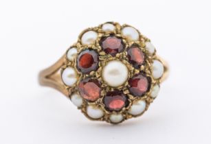 A garnet and pearl set 9ct gold cluster ring, circular design set with small half pearl and round