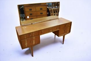 A mid 1970s teak dressing table and matching chest of two above two drawers, McIntosh & Sons mark.