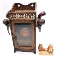 A late Victorian/Edwardian oak smokers cabinet with pierced  gallery top side pipe holders, glazed