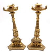 A pair of brass Empire-style candlesticks