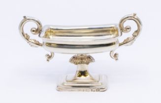 A Russian silver salt cellar, having stylised scrolled twin handles, stepped rectangular footed