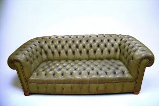 A mid 20th Century button back Chesterfield three seater sofa, bottle green with foot pads.