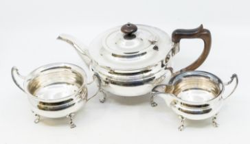 A 20th century silver plated three piece tea set to include; tea pot with wooden handle and