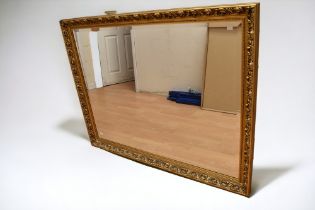 A large modern framed mirror with gilt detail.