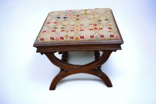 A Victorian stool with curved legs and tapestry style embroidered top. Some signs of wear and