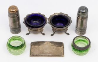 A pair of silver pepperettes, two pairs of glass lined salts and a silver card case with family cres