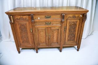 A late 19th Century oak dresser base of two central drawers above cupboard door, flanked by two side