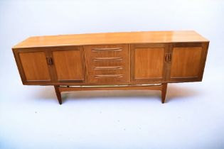 An early 1970s G plan sideboard with cupboards either side, having two door to each with four
