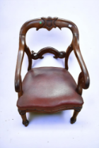 A large solid mahogany mid 19th Century scrolled arm chair, padded seat, turned front legs, shield