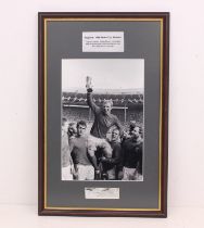 World Cup: A framed and glazed print of Bobby Moore holding the Jules Rimet Trophy aloft. With