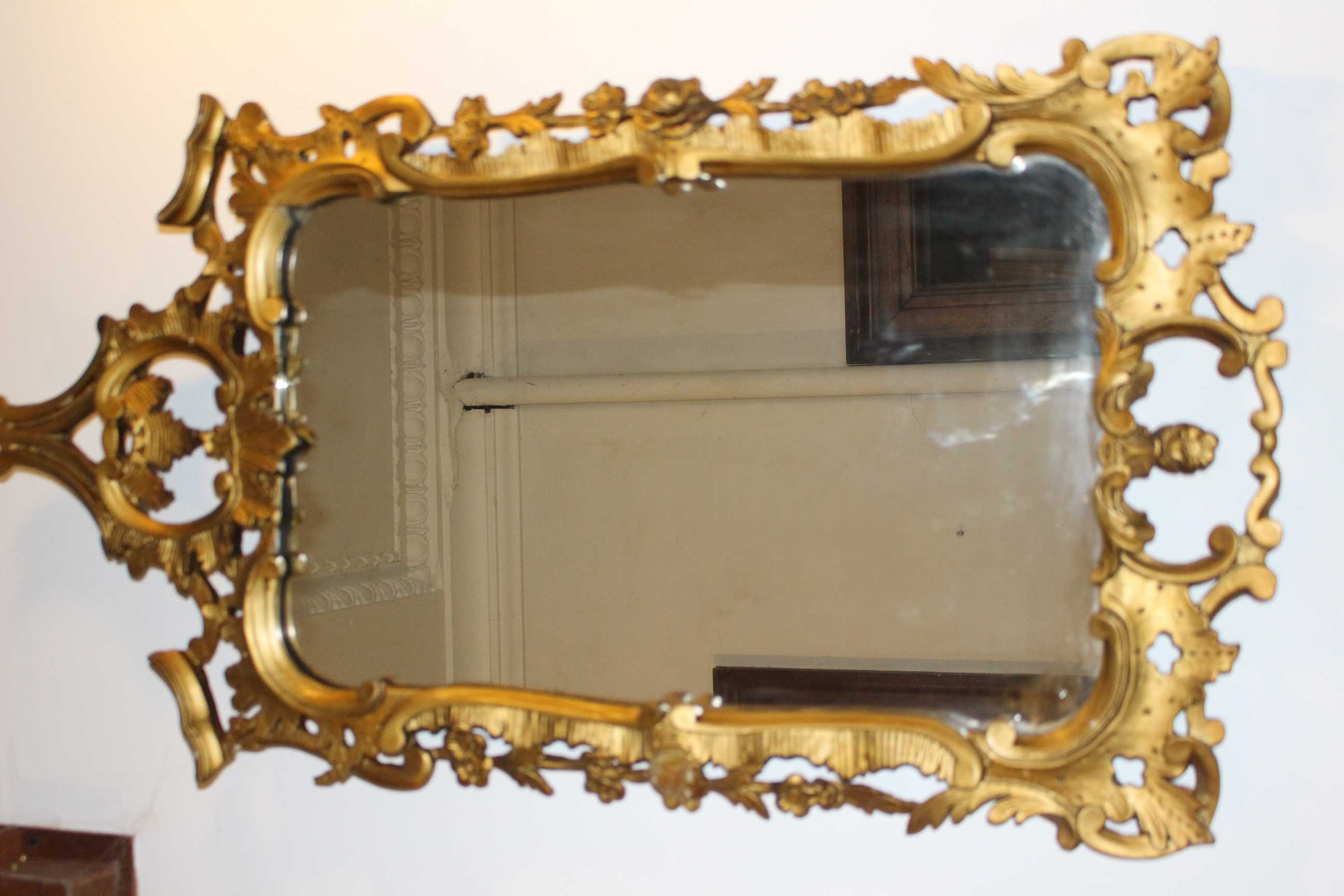 A Regency gilt gesso overmantel mirror, the rectangular plate in reeded ebonized fillet flanked by