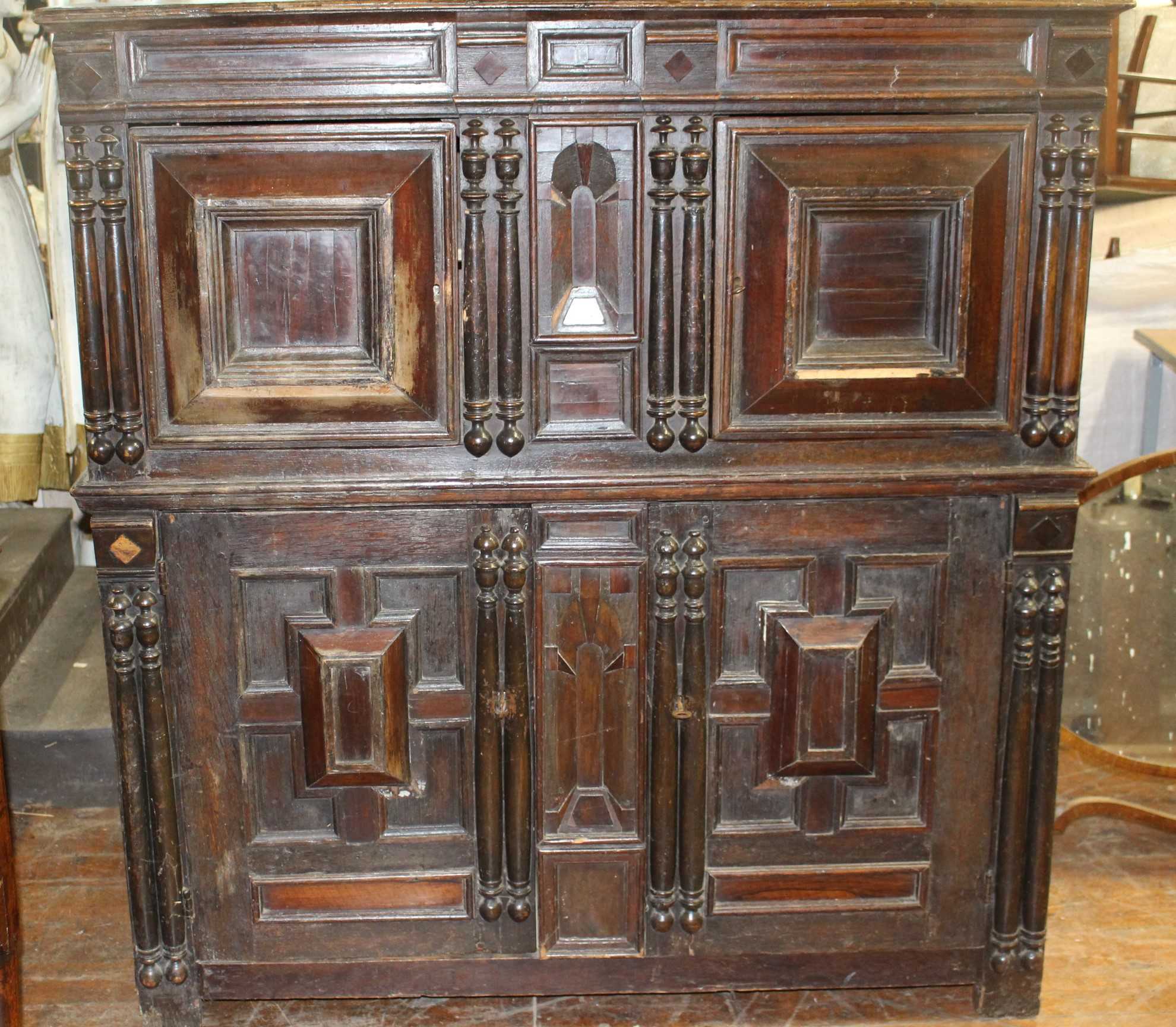 A 17th Century and later panelled oak cupboard, the upper section with moulded edge above a pair