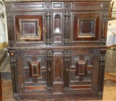 A 17th Century and later panelled oak cupboard, the upper section with moulded edge above a pair
