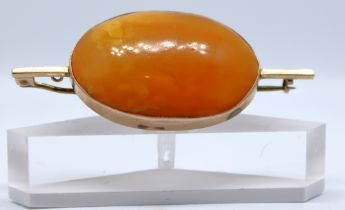 Unmarked Rose Gold Oval Cabochon Butterscotch Amber Brooch.  The Oval Cabochon Butterscotch Amber