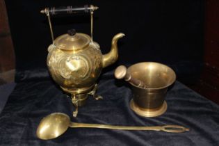 An 18th century brass pestle and mortar, a Victorian brass tea kettle on stand with burner and a