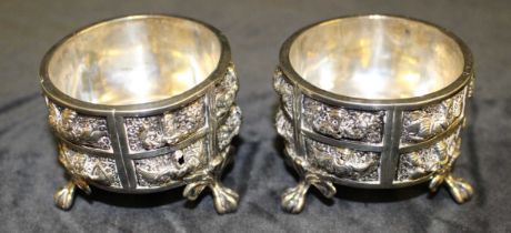 A pair of Indian white metal open salts repousse with mythical creatures, each on three claw and