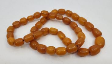 A string of butterscotch amber beads, of near cylindrical form the largest approx. length 16mm x