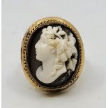 A yellow metal cameo ring, the oval cameo carved with a lady in left profile, size UK O 1/2. (