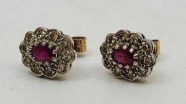 A pair of 9ct. gold, ruby and diamond cluster stud earrings, having oval mount set mixed oval cut