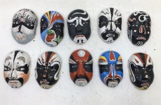 A collection of ten small Chinese porcelain theatre masks together with Asian/Sino-Tibetan masks (