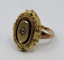 A yellow metal and diamond set ring, the oval mount probably originally from a brooch set single