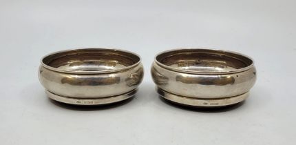 A pair of silver wine coasters, by W I Broadway & Co, Birmingham 1982 & 1986, of plain circular form