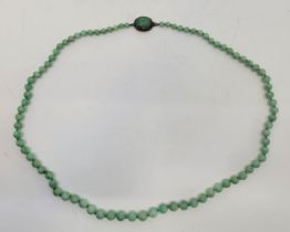 A Chinese graduated green jade necklace, the white metal clasp set carved jade beetle, the verso