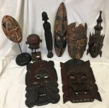 A collection of carved wooden masks and similar (a/f)