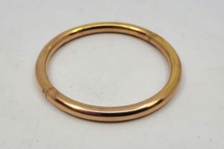 A 10ct. rose gold hinged bangle, outer diameter 8.3cm. (16.8g)