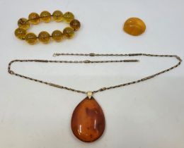 An orange amber pendant, of pear shape form, semi-translucent with fossilised insect to interior,