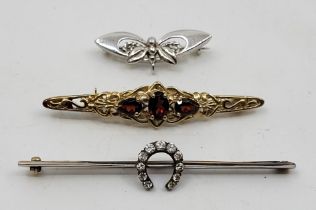 An unmarked yellow and white metal diamond lucky horseshoe bar brooch, the horseshoe pave set eleven