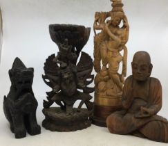 A collection of Asian carved wooden figures. (4)