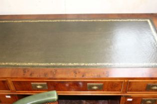 A late 20th century brass bound office campaign style twin pedestal desk with green leather top.