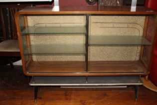 A 1950's oak glazed display cabinet with a pair of glazed sliding doors enclosing shelves above