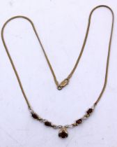 9ct Gold Garnet & Diamond Necklace.  The Necklace contains five Oval Brilliant Cut Garnets.  The