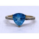9ct Yellow Gold Topaz and Diamond ring.  The Blue Trilliant Cut Topaz measures approx. 8mm x 8mm.