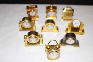 10 x Miniature brass mantel clock in wall mount display case, clocks are all sold as untested.