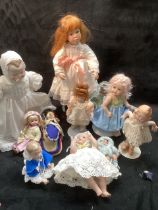 Modern vintage porcelain replica antique dolls including smaller dolls and baby dolls as a group. (