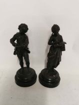 A pair of late 19th century French spelter figures of a boy and girl on turned wooden bases. Each