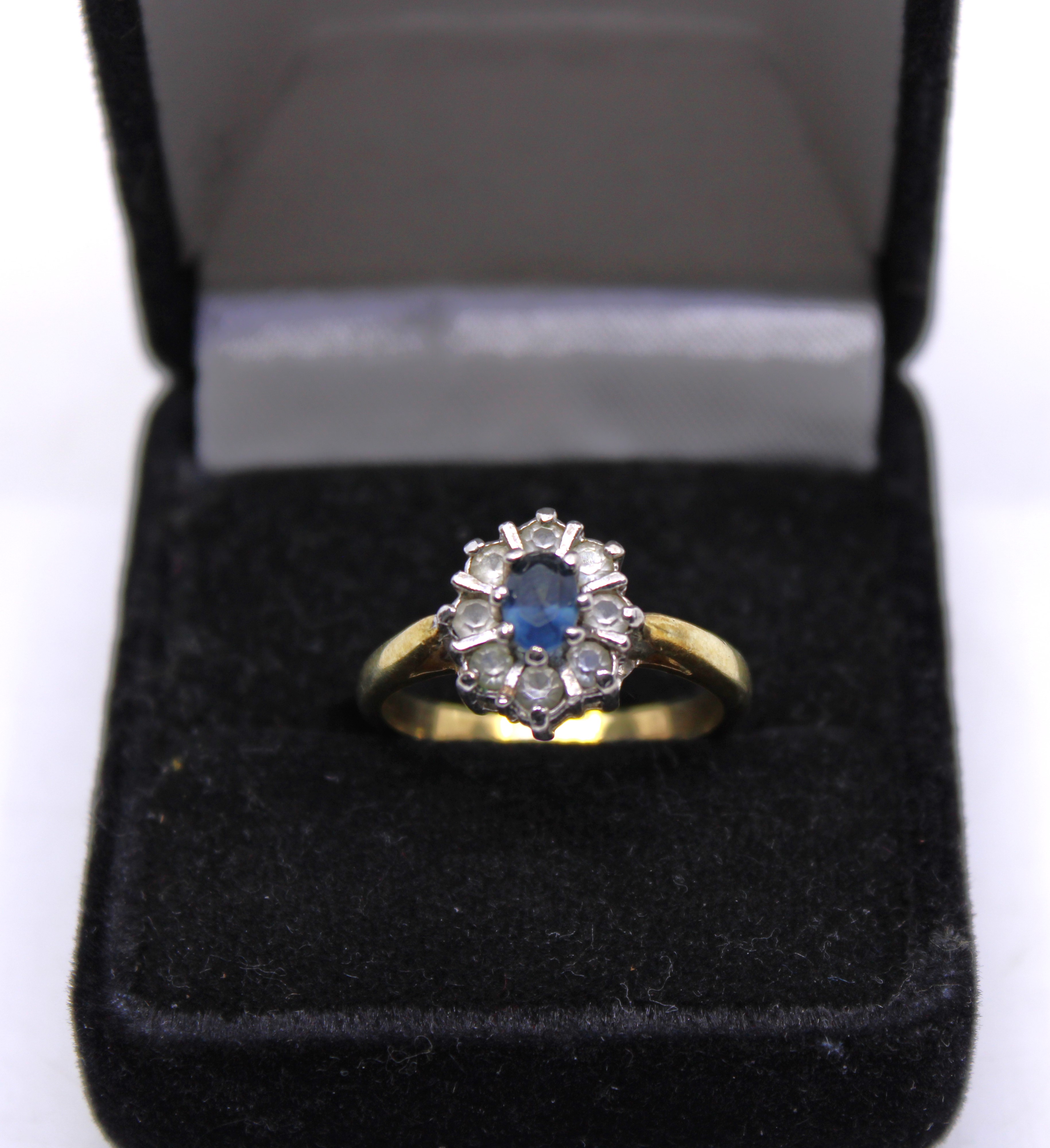 Unmarked Yellow Metal Sapphire and Colourless Stone ring. Tested as 9ct Gold.  The Oval Brilliant