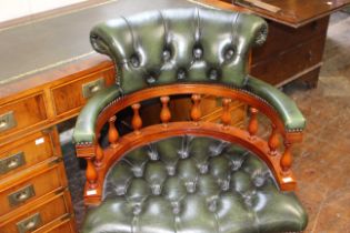 A Captains swivel arm chair with green leather buttoned upholstery. (1)