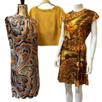 A group of 1960s day dresses in varying fabrics and prints with a 60s/70s purple maxi dress and a