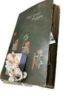 An antique postcard album holding postcards mostly from 1900s to the 1940s with some later including