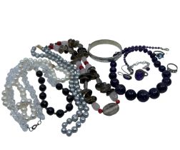 A collection of costume jewellery to include strings of grey and white pearls that appear to slot