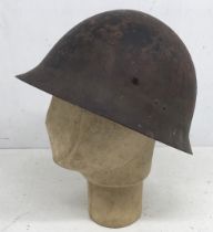 A WW2 era Japanese type 90 battle damaged steel helmet. A semi relic piece, with just the shell