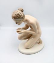 Rouzan Pottery - a figure of a woman, modelled kneeling raising her hands up to her face, glazed