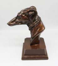 Bronzed sculptural head of a greyhound on a wooden plinth. Unsigned. Height approx 25cm.