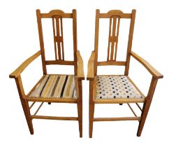 A pair of Arts & Crafts (c.1910) light oak dining chairs, both having central rectangular stylised