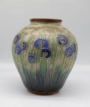 A 1930s Royal Doulton stoneware vase blue flowers amidst green leaves on a pale green ground.