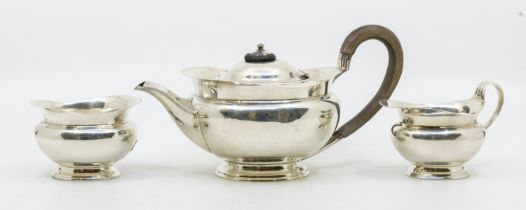 An Edwardian silver three piece tea set consisting of tea pot with fruitwood handle and ebonised